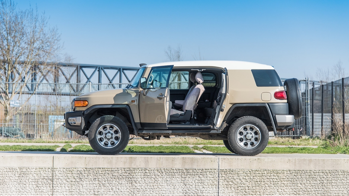 Toyota-FJ-Cruiser-exterieur-stilstaand-linker-zijaanzicht-open-deur-beige